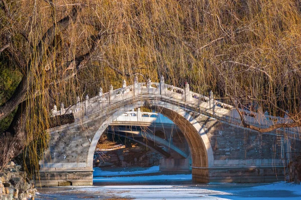 北京の頤和園に伝統的な湾曲した石造りの橋がある黒湖 — ストック写真