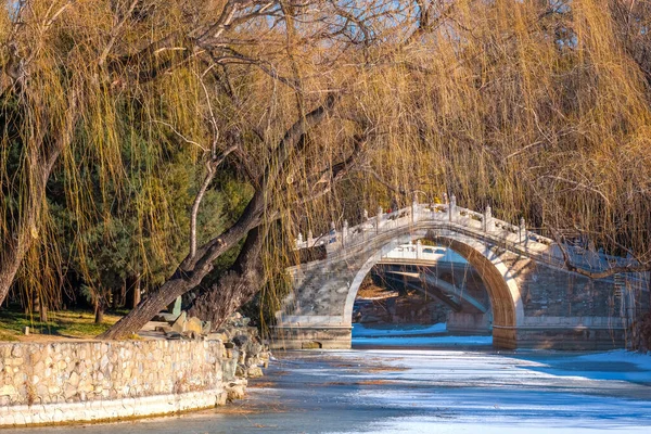 北京の頤和園に伝統的な湾曲した石造りの橋がある黒湖 — ストック写真