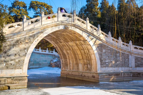 北京の頤和園に伝統的な湾曲した石造りの橋がある黒湖 — ストック写真