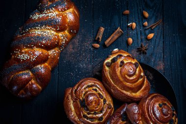 Ev yapımı çörekler ve taze tarçın tarçın, badem, karanlık rustik arka plan üzerinde Yıldız anason ile fotoğrafı kapatın. Homemad fırını. Kavram düşük anahtar gıda fotoğraf. Kopya alanı metin, logo, marka için