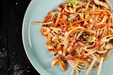 Seçici odak tavuk ve sebze koyu arka plan üzerinde Çin Eriştesi üzerinde. Çin mutfağı, üstten görünüm gıda, kopya alanı için metin, koyu arka plan