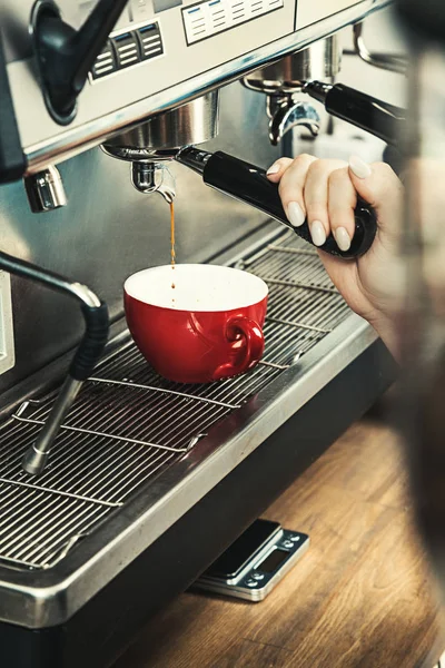 Women Barista using coffee machine for making coffee in the coffee shop. Toned picture. Copy space for text, logo or brand