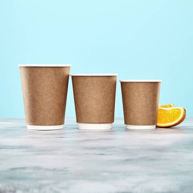 Şeftali arka plan üzerinde kahverengi kahve fincanı. Tek kullanımlık kağıt yemekleri. Logo, metin ya da marka için kopya alanı