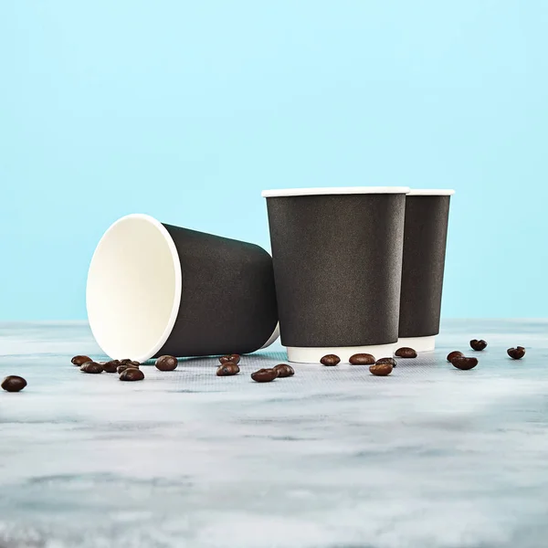 Zwarte Koffiekopje Met Koffiebonen Blauwe Achtergrond Wegwerp Papieren Gerechten Ruimte — Stockfoto