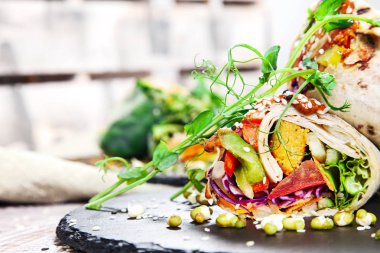 Bir kara tahta ve ahşap arka plan üzerinde taze vejetaryen ekmek falafel, otlar ve baharatlar ile. Sağlıklı ev yapımı vegan yemek veya aperatif. Shawarma görünümü kapatın. Logo, metin ya da marka için boş alanı Kopyala.