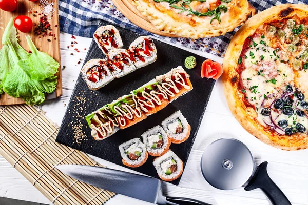 食品パーティー テーブルの概念 おやつピザや寿司の平面図です テキスト ロゴまたはブランドの無料コピー スペースを持つ木製白地イタリア料理と日本料理 レストランの写真 — ストック写真