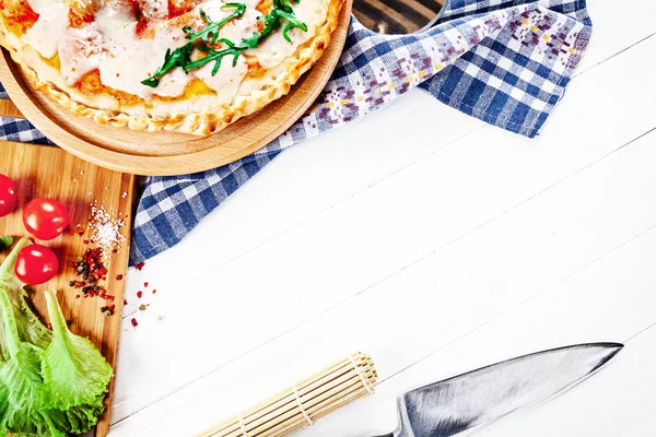 Üstten görünüm Beyaz ahşap zemin üzerinde İtalyan mutfağı. alzone pizza malzemeleri gemide. Metin, logo veya marka için sağlıklı ev yapımı yiyecek ücretsiz kopya alanı ile. Tarifi için arka plan resmi