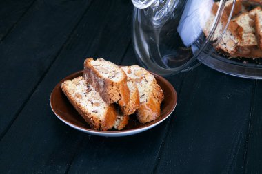 Cantucci veya cantuccini tanımlama karanlık ahşap arka plan üzerinde görünümü kapatın. Tatlı ekmek coockie yiyecek. İtalyan tatlı. Ev yapımı yemekler. Resim tarifi için. Ücretsiz kopya alanı için metin, logo