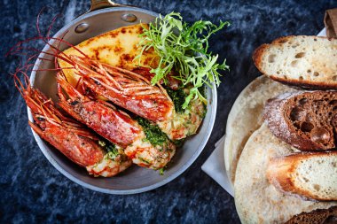 Üstten Görünüm üzerinde mermer masa üzerinde tavada karides. Yeşil ve ekmek ile deniz ürünleri. Restoran yemek menüsü, tarifi fotoğraf kopya alanı ile