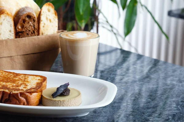 Delicious flat lay food for breakfast on marble table. Close up on Fried toast with pate, bread and coffee latte with copy space for design in modern interior. European cuisine fresh breakfast