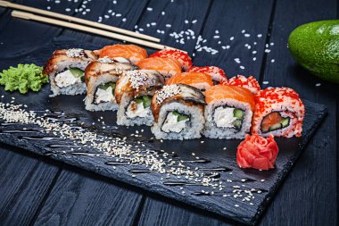 Suşi birtakım karanlık taş zencefil ve wasabi ve ahşap siyah ahşap masa eşliğinde somon ile alır. Taze Japon mutfağı. Asya gıda görünümü kapatın. Suşi görüntü menüsü.