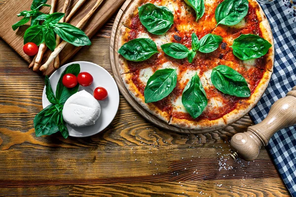 Top view on fresh homemade margarita pizza on wooden table. Top view food with copy space for design. Pizza with ingridients: cherry tomato, mozarella. Italian cuisine — Stock Photo, Image