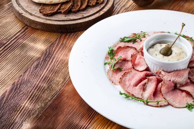 Geleneksel İtalyan mutfağı Vitello tonnato görünümü yakın. Ahşap arka planda Dana balığı krem sos ve ekmek turşu ile bir çanak. Tasarım, metin için boşluk kopyalayın. Yemekten önce atıştırmak. Yakın çekim gıda
