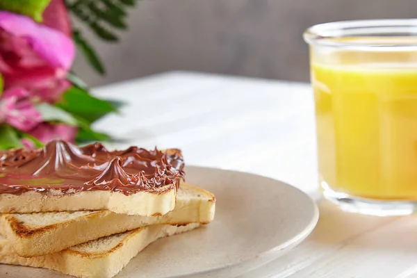 Nahsicht auf Toast mit Erdnussbutter. Frühstückskonzept mit Orangensaft, Blumen und Toast auf weißem Holzgrund. traditionelles Sommerfrühstück. Komposition mit Kopierraum für Design — Stockfoto