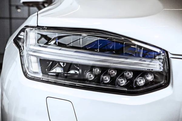 Macro view of modern car headlight SUV with noise graine effect. car xenon lamp headlight. detail view on car xenon lamp