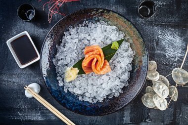 Taze dilimlenmiş somon sashimi üst görünümü koyu arka plan üzerinde buz ile kase de servis edilir. japon gıda sashimi. Japonya restoran menüsü. Tasarım için kopya alanı. En iyi deniz ürünleri. Sağlıklı yemek