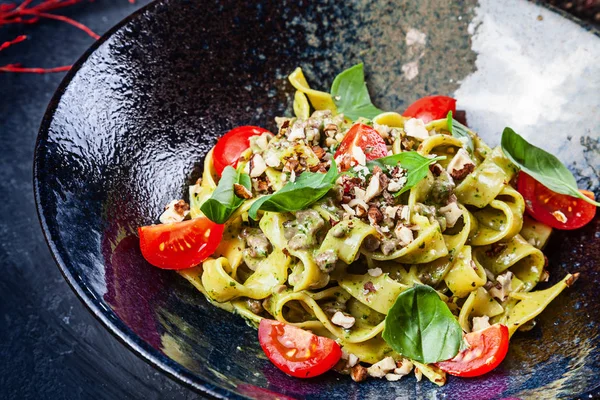 Domates, fesleğen ve dana eti, parmesan ile taze ev yapımı İtalyan makarna. Yakın görünüm seçici odak. İtalyan mutfağı. Kopya alanı olan yiyecekler. Koyu kasemakarna Fettuccine. İtalyan tarzı akşam yemeği