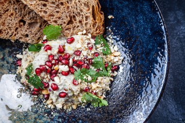 Koyu plaka Baba ghanoush üst görünümü. Geleneksel Orta Doğu mutfağı. Gıda. Tahin ile karıştırılmış pişmiş patlıcan püremez. Tasarım için kopyalama alanı