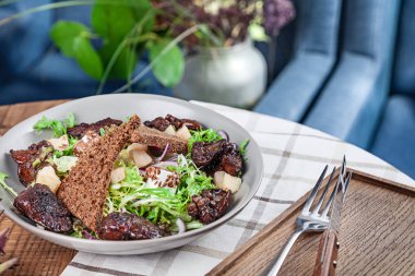 Taze sağlıklı salatanın yakından görünümü. Marul, tavuk ciğeri, kruton, kırmızı soğan ve peynir ile Salata. Öğle yemeği kase restoranda servis edilir. Dengeli sağlıklı gıda kavramı. meze plakası