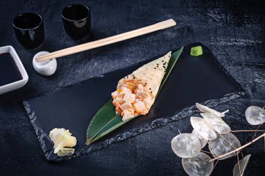 Soya sosu ve zencefil ile koyu taş tabakta servis taraklı ve Tobico havyar ile mamenori lezzetli el rulo suşi yakın çekim. Kopya alanı. Temaki, Japon mutfağı. Sağlıklı gıda