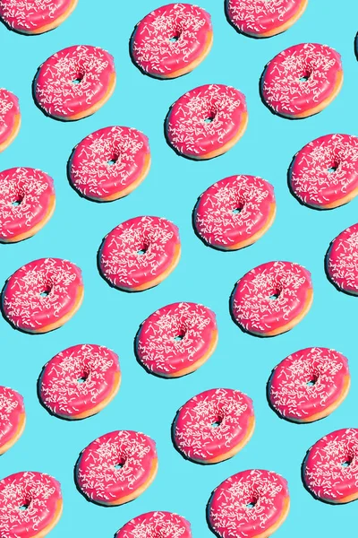 Creatieve poster met donuts. Donuts op een blauwe achtergrond. Platte lay patroon van donut 45 graden, popart. Roze geglazuurde donut creatief concept. Minimale voedsel isometrisch. Abstract dessert — Stockfoto