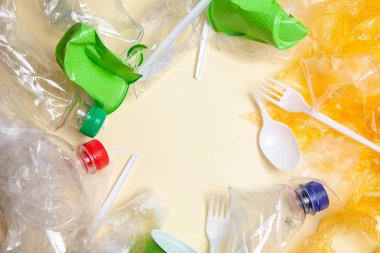 Geri dönüşüm konsepti. ekoloji, çevre kirliliği. Ezilmiş ve parçalanmış plastik arka plan. Üst görünüm kopya alanı. Sarı arka plan yatay. hazır Ban plastik. Plastik kirliliği