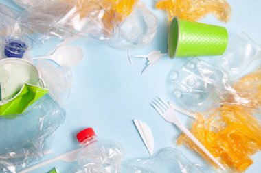 Geri dönüşüm konsepti. ekoloji, çevre kirliliği. Ezilmiş ve parçalanmış plastik arka plan. Üst görünüm kopya alanı. Mavi arka plan yatay. hazır Ban plastik. Plastik kirliliği