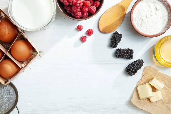 Food background top view. Mock up with ingredients for cooking pie or pancake on white background. Horizontal. Summer berry. Various cooking ingredients with copy space frame. Flat lay