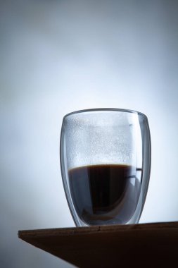 Bir beton duvarın önünde coffe sıcak cam yakın görünümü. Sabah içkisi kokundu. Kahvaltı, creaitive natürmort fotoğraf gıda. trending çift duvarlı cam. Bir fincan espresso kahve