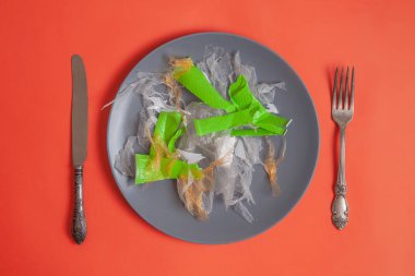 Plastik kirliliği için konsept afiş. Sanat plastik salata plaka üzerinde servis edilir. Ban plastik kavramı. Yemeye hazırım. gıda konsepti. Kopyalama alanı ile yukarıdan görüntüleyin. turuncu arka plan