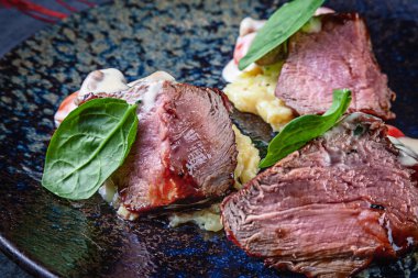 Domates ve patates püresi ile koyu tabaktabakta servis kan ile dilimlenmiş Sulu orta biftek yakından görünümü. Et yemeği. Amerikan yemekleri. Tasarım için kopyalama alanı