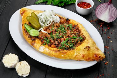 Geleneksel Gürcü açık pasta et ile. soğan ve baharatlar ile toprak sığır eti, otlar ve baharatlar ile karanlık arka planda Gürcü ekmek pişmiş. Öğle yemeği için lezzetli yemekler.