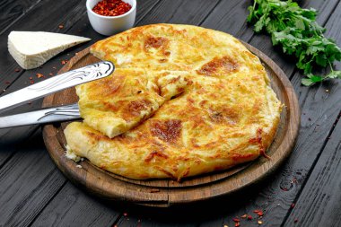 Baharatlar ile koyu arka planda görünüm Khachapuri yakın. Geleneksel. Beyaz mutfak. Restoran yemeği. Peynir ve gronded beff ile Khachapuri pasta. Öğle yemeğinde et yemeği, karanlık arka plan. Boşluk Kopyala