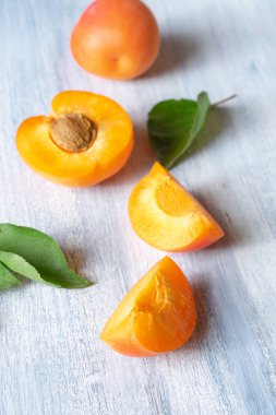 Kayısı ile Dikişsiz desen. Kayısı meyveleri ve yarısı mavi arka planda düz yatıyordu. Üst görünüm. Doğal, yeşil konsept. Boşluk Kopyala. Taze kesilmiş kayısı meyve dilimleri. Yaratıcı düzen. Gıda konsepti