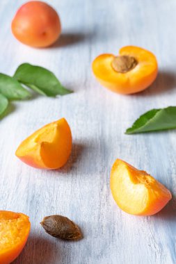 Kayısı ile Dikişsiz desen. Kayısı meyveleri ve yarısı mavi arka planda düz yatıyordu. Üst görünüm. Doğal, yeşil konsept. Boşluk Kopyala. Taze kesilmiş kayısı meyve dilimleri. Yaratıcı düzen. Gıda konsepti