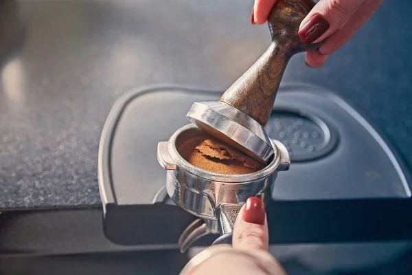 Barista segurando portafilter e adulteração de café. Café preparar conceito. Mão de barista em frente a caixa. Barista pressiona café moído usando adulteração. Imagem dentada. Copiar espaço para o design. casa de café — Fotografia de Stock