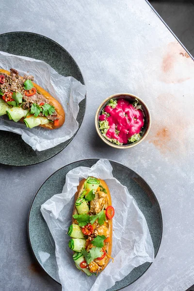 Pan-asian cuisine. traditional banh-mi sandwich with sweet and sour chicken, parsley, cucumber, chili pepper. Famous Vietnamese fastfood. street food concept on grey stone background. bahn mi top view