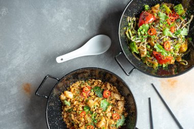 Pad tay ve pho noodle üst görünümü. Kopya alanı ile düz pan-asya gıda yatıyordu. Geleneksel Asya sokak yemekleri. tavada kızarmış pirinç şehriye. Baharatlı yemekler. Gri taş arka plan. Menü veya afiş