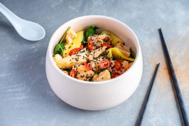 Gri taş arka plan tay tarzı kase salatası. Tatlı ve ekşi tavuk, biber biber, mango, ıspanak ile Sıcak salata. Tasarım için kopya alanı. Düz yatıyordu pam-asya gıda