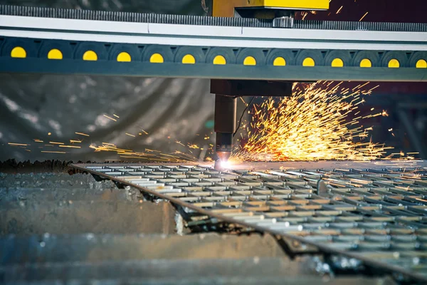 Close up view on CNC plasma cutting machine. CNC gas cutting metal sheet. Laser or plasma cutting technology. Selective focus and noise grain. sparks. factory concept with copy space