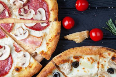 Ingridients ile koyu ahşap arka plan üzerinde üst görünüm iki pizza. Et gıda arka plan ile İtalyan pizza. Lezzetli ev yapımı İtalyan mutfağıpizza. Fast food