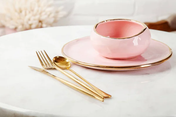 Emty food pink cookware. Stylish kitchen utensils on light marble table with copy space. Poster for sale. Modern cookware set for dessert or lunch. Pink plate and bowl
