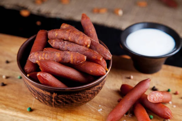 Vista da vicino sulle salsicce. Gustosi salumi di wurst alla birra. stuzzicante birra spuntino sekective focus. Tavolo con salsiccia, salsa bianca e bicchiere di birra. Sfondo scuro — Foto Stock