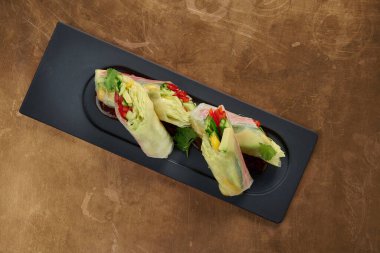 Avokado, salatalık, salatalık, marul ve siyah bir tabakta dolma biber ile vejetaryen börekleri. Görüntüyü kapat