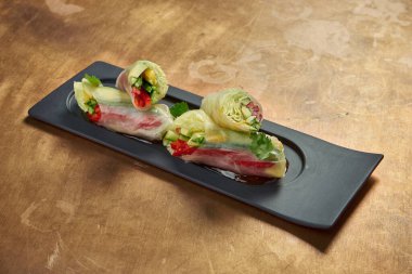 Avokado, salatalık, salatalık, marul ve siyah bir tabakta dolma biber ile vejetaryen börekleri. Görüntüyü kapat