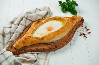 Beyaz arka planda Khachapuri 'yi baharatlarla kapat. Geleneksel Gürcistan usulü peynirli ekmek. Adjarian 'da Khachapuri. Peynirli ve yumurtalı turta
