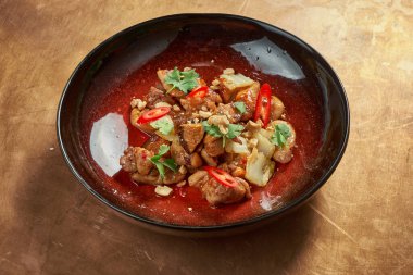 Lezzetli Asya usulü bir yemek, tatlı ve ekşi soslu, şitake mantarlı ve kırmızı biberli, metal kaplı, bakır arka planda. Restoran servisi.