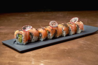 Klasik Japon suşi dürümleri. Philadelphia krem peynirli, avokado ve somon balıklı ve bakır kaplamalı.