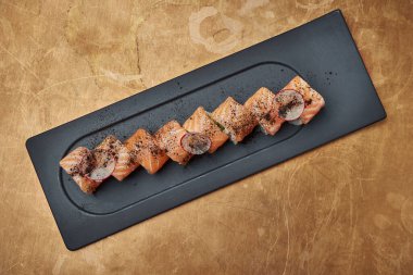 Klasik Japon suşi dürümleri. Philadelphia krem peynirli, avokado ve somon balıklı ve bakır kaplamalı.