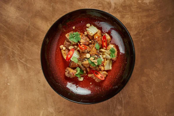 一个美味的亚洲风格的菜 猪肉在甜和酸的酱汁与芝麻蘑菇和辣椒在一个金属 铜背景的红盘 餐厅服务 — 图库照片